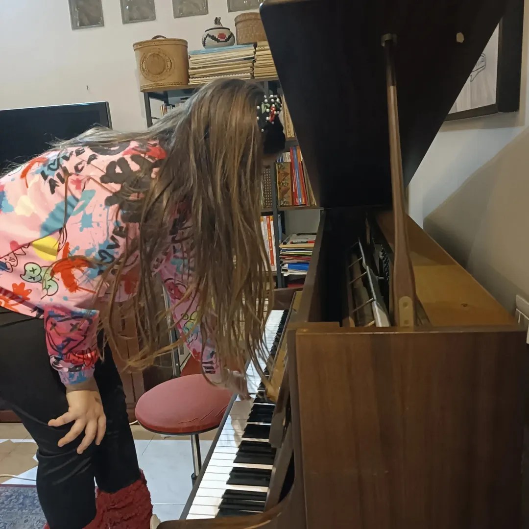 Ragazza di 14 anni esplora il pianoforte durante una lezione individuale a Roma